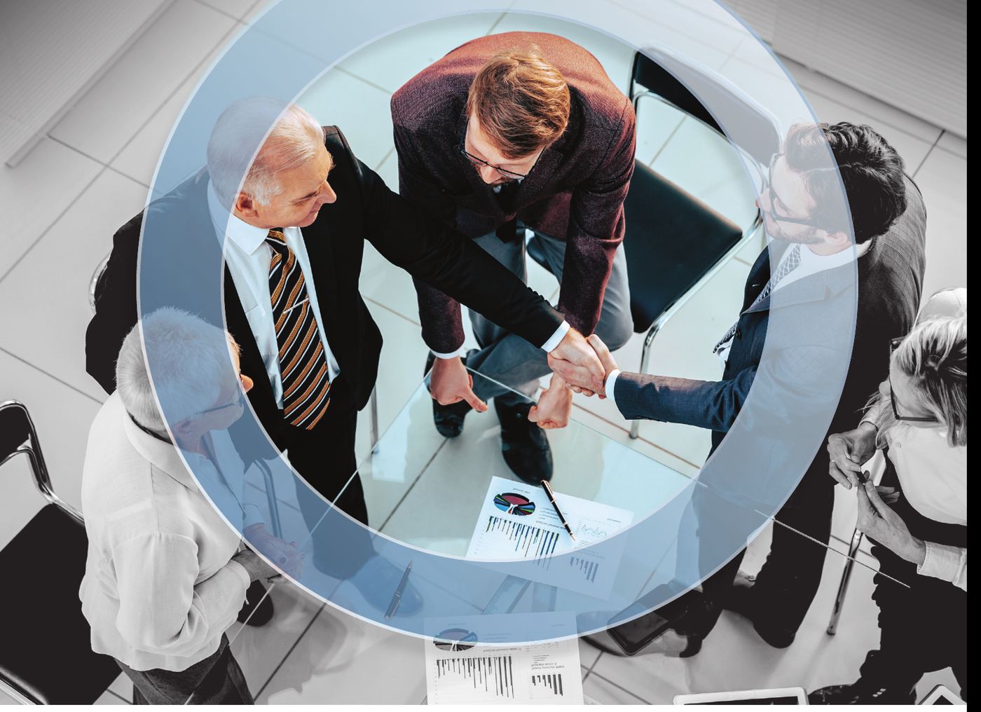 Professionisti che si stringono la mano attorno a un tavolo di lavoro